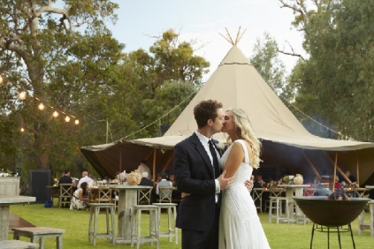 Pareja besándose delante de una carpa